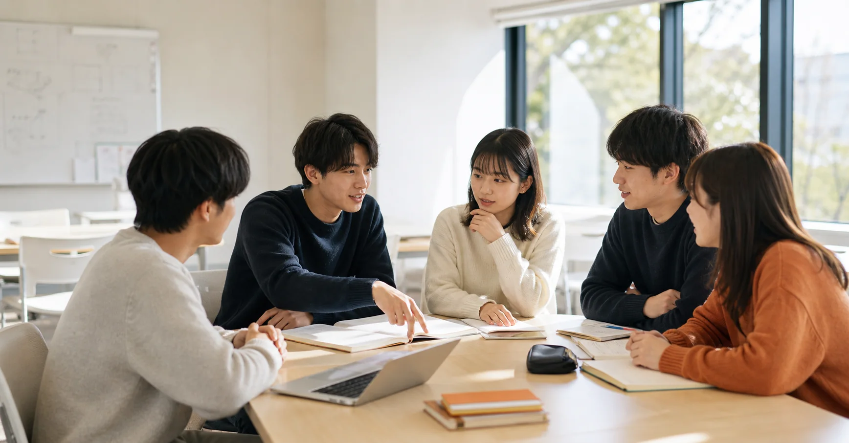 明るいゼミ室で議論する大学生たち